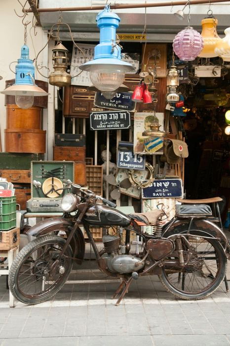Antique street shop with Hebrew signs and a motorcycle